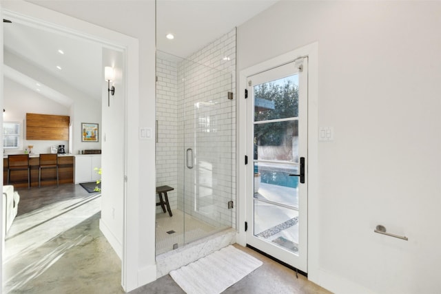 bathroom with lofted ceiling, an enclosed shower, and concrete flooring