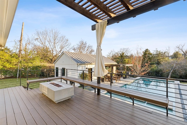 wooden terrace with an outdoor fire pit, a pergola, and a fenced in pool