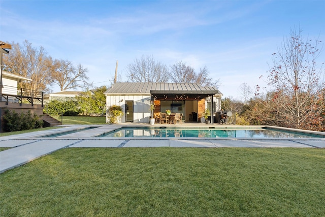 view of swimming pool featuring a yard and an outbuilding