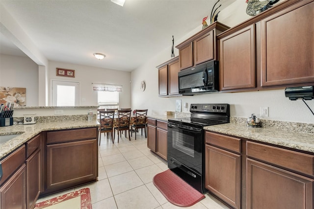 kitchen with black appliances, light tile patterned floors, and light stone counters