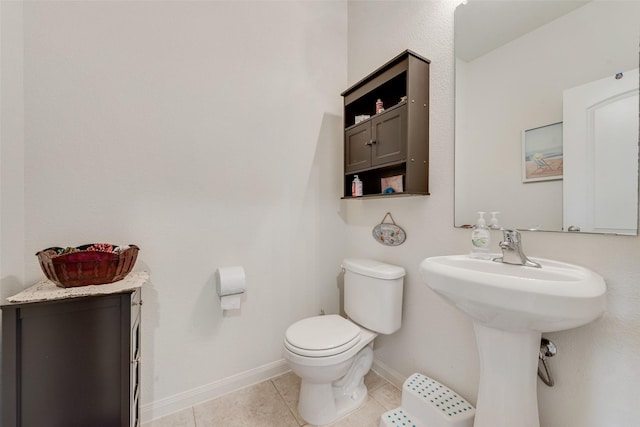 bathroom with toilet, tile patterned floors, and sink