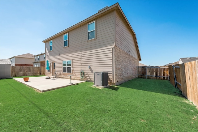 back of property with central AC unit, a patio, and a yard