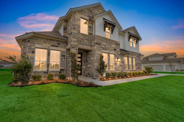 view of front of home featuring stone siding and a lawn