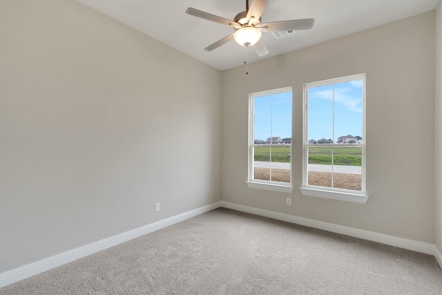 carpeted empty room with visible vents, baseboards, and ceiling fan