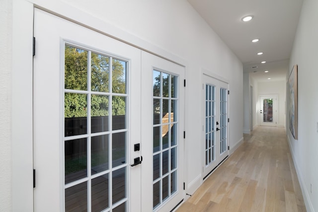 hall featuring french doors and light wood-type flooring