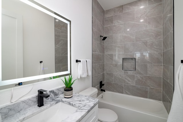 full bathroom with toilet, vanity, and tiled shower / bath