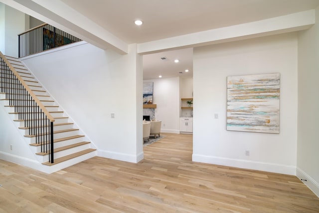 interior space with a fireplace, hardwood / wood-style flooring, and beam ceiling