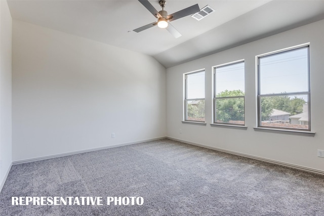 carpeted spare room featuring ceiling fan and vaulted ceiling