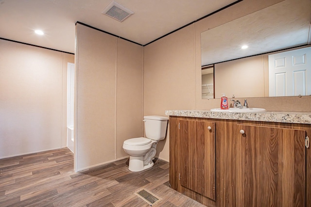 bathroom with toilet, wood-type flooring, and vanity