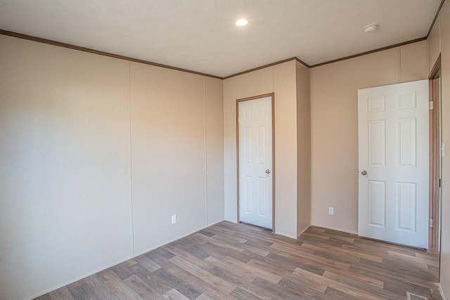 unfurnished bedroom with crown molding and wood-type flooring