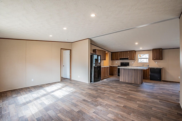 kitchen featuring a textured ceiling, a center island, lofted ceiling, dark hardwood / wood-style flooring, and black appliances