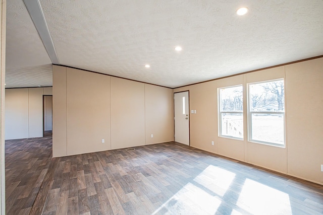 unfurnished room with dark wood-type flooring and a textured ceiling