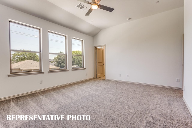 carpeted spare room with ceiling fan and vaulted ceiling