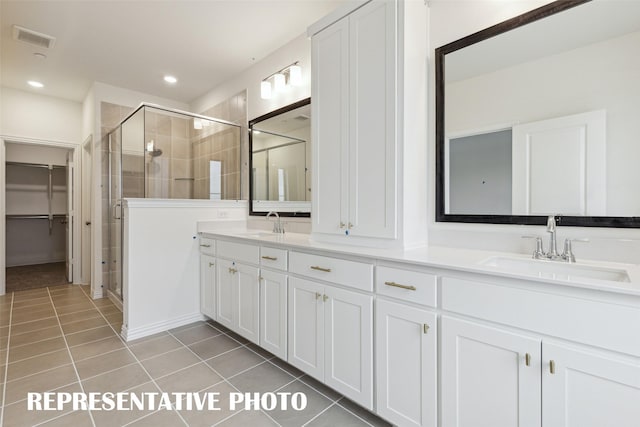 bathroom featuring a shower with door, vanity, and tile patterned floors