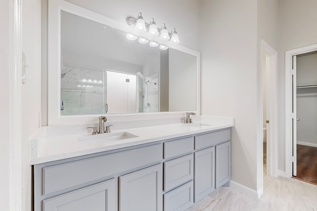 bathroom with a shower with shower door and vanity