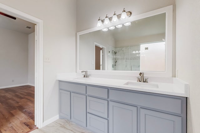 bathroom with a shower with shower door, wood-type flooring, and vanity