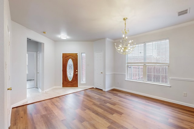 foyer entrance with light wood-type flooring and a chandelier