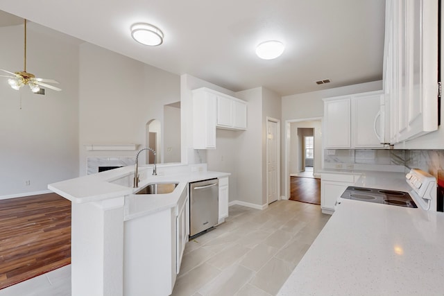 kitchen with ceiling fan, kitchen peninsula, sink, white appliances, and white cabinets