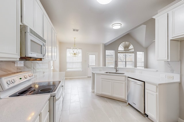 kitchen with white cabinetry, sink, white appliances, and a chandelier