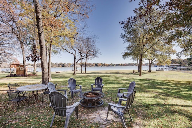 view of yard with an outdoor fire pit and a water view