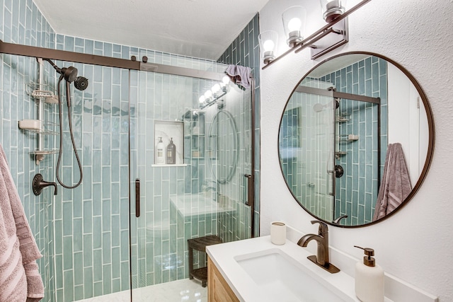 bathroom with vanity and a shower with shower door