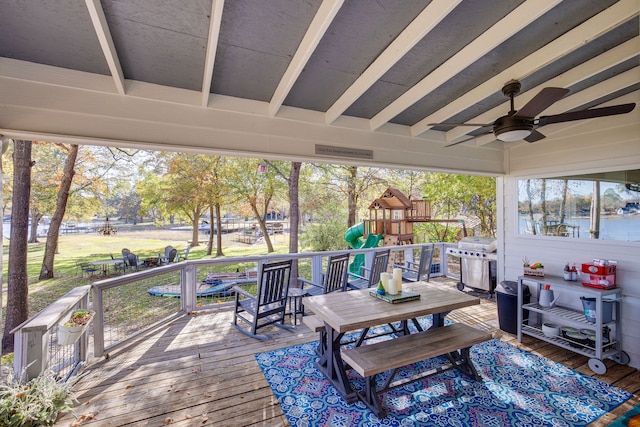 wooden deck featuring a playground, ceiling fan, and a grill