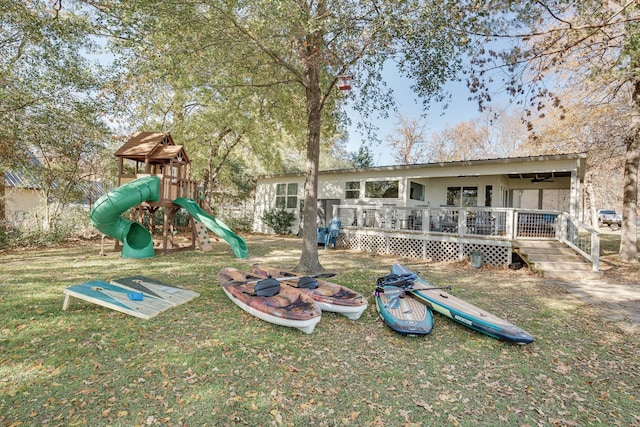 view of jungle gym featuring a lawn and a wooden deck