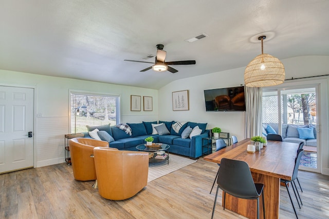 living room with light hardwood / wood-style floors, ceiling fan, and vaulted ceiling