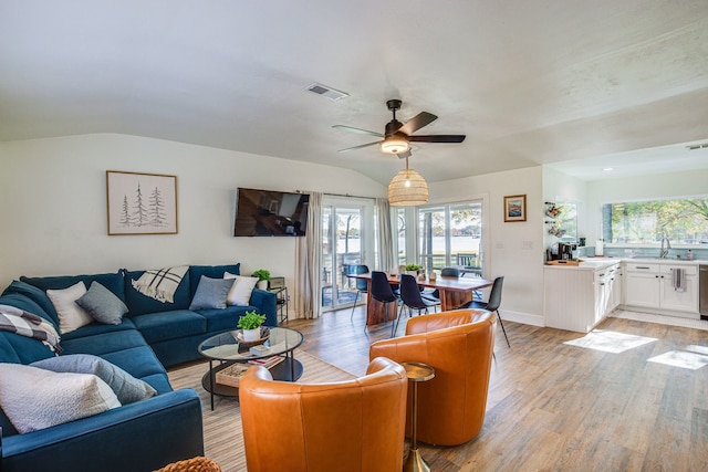 living room featuring light hardwood / wood-style floors, ceiling fan, lofted ceiling, and sink