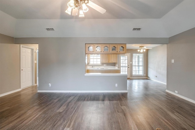 unfurnished living room featuring ceiling fan and dark wood-type flooring