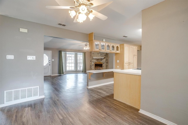 kitchen featuring a fireplace, ceiling fan, and dark hardwood / wood-style floors