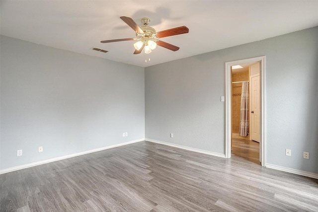 empty room with ceiling fan and light hardwood / wood-style floors