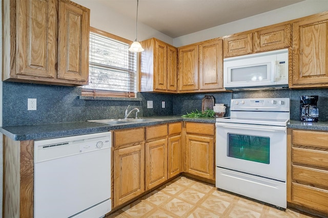 kitchen with sink, white appliances, tasteful backsplash, and hanging light fixtures