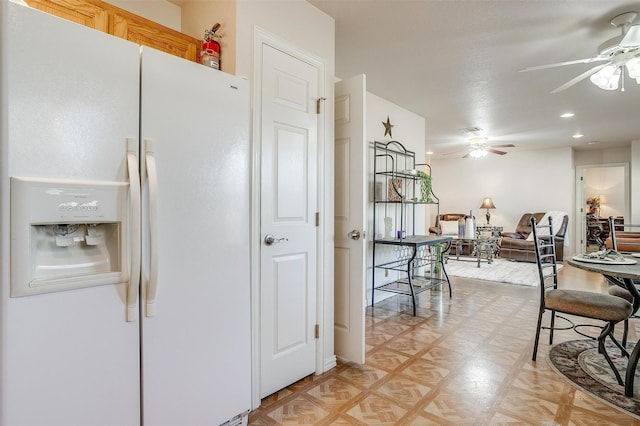 kitchen featuring ceiling fan, white fridge with ice dispenser, and light parquet flooring