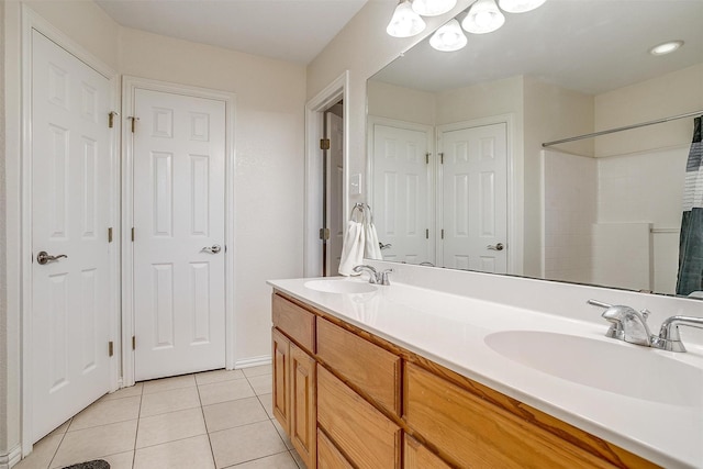 bathroom with walk in shower, vanity, and tile patterned floors