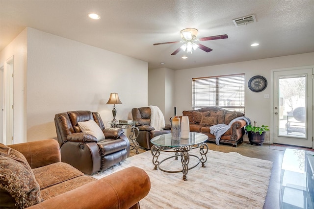 living room with a textured ceiling and ceiling fan