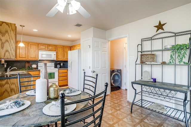 kitchen with sink, washer / clothes dryer, white appliances, decorative backsplash, and hanging light fixtures