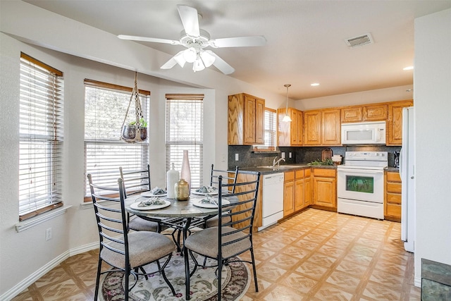 kitchen with white appliances, hanging light fixtures, backsplash, ceiling fan, and sink