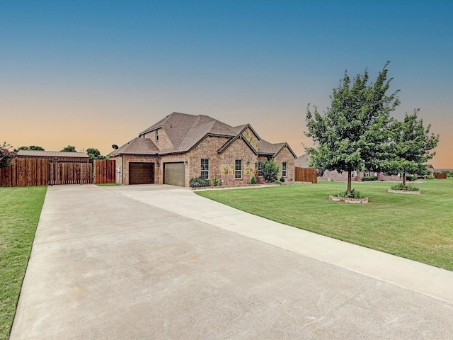 french provincial home with a yard and a garage