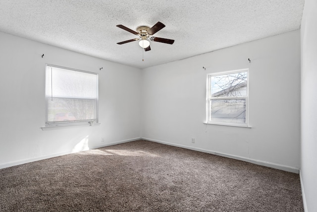 carpeted empty room featuring ceiling fan and a textured ceiling