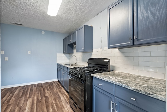 kitchen featuring black gas range, blue cabinets, sink, a textured ceiling, and backsplash