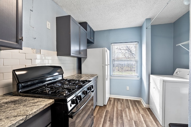 kitchen featuring washer / clothes dryer, a textured ceiling, hardwood / wood-style flooring, black gas stove, and decorative backsplash