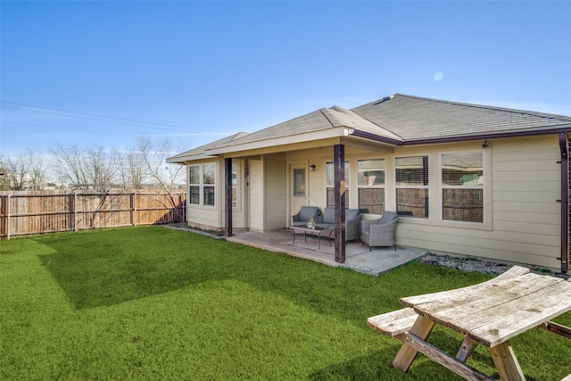 rear view of property featuring fence private yard, a patio, and a lawn