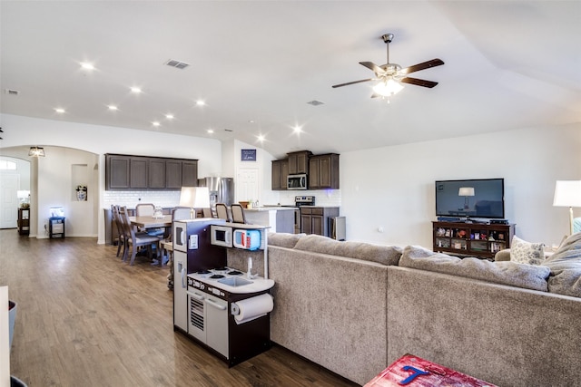 living room featuring lofted ceiling, ceiling fan, and dark wood-type flooring