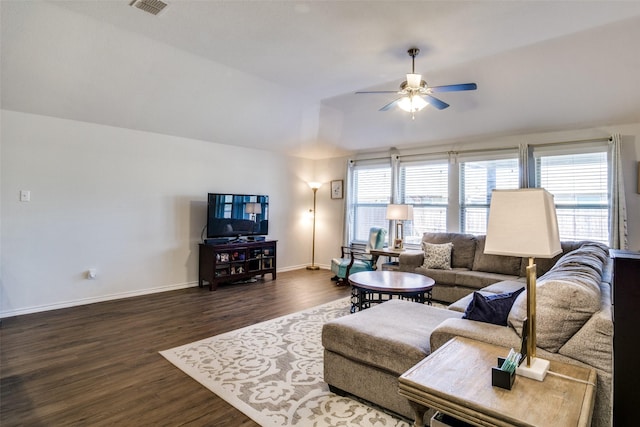 living room with lofted ceiling, ceiling fan, visible vents, baseboards, and dark wood finished floors