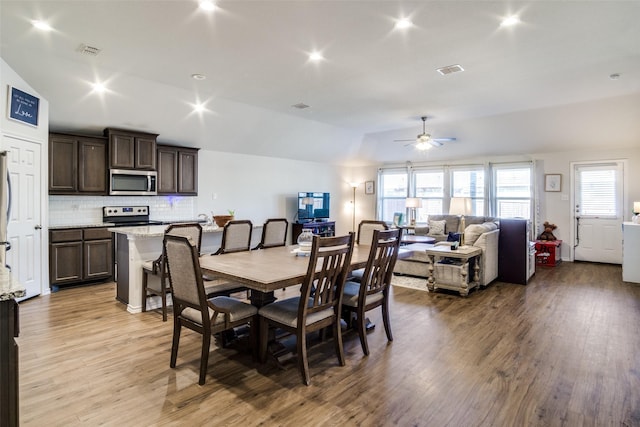 dining space featuring ceiling fan, light hardwood / wood-style flooring, and vaulted ceiling