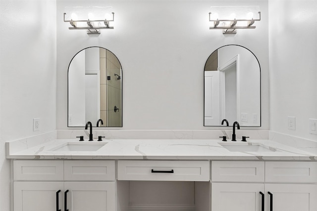 bathroom with tiled shower and vanity