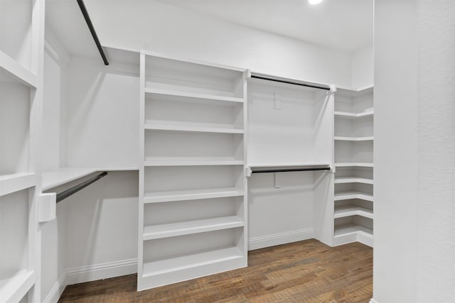 walk in closet with dark wood-type flooring