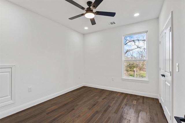 spare room featuring dark wood-type flooring and ceiling fan