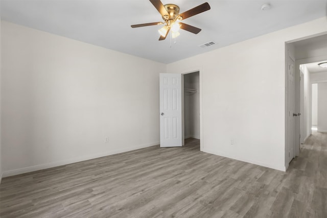 unfurnished bedroom with ceiling fan, light hardwood / wood-style floors, and a closet